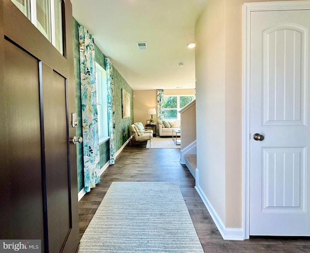 foyer with stairs, baseboards, visible vents, and dark wood-style flooring