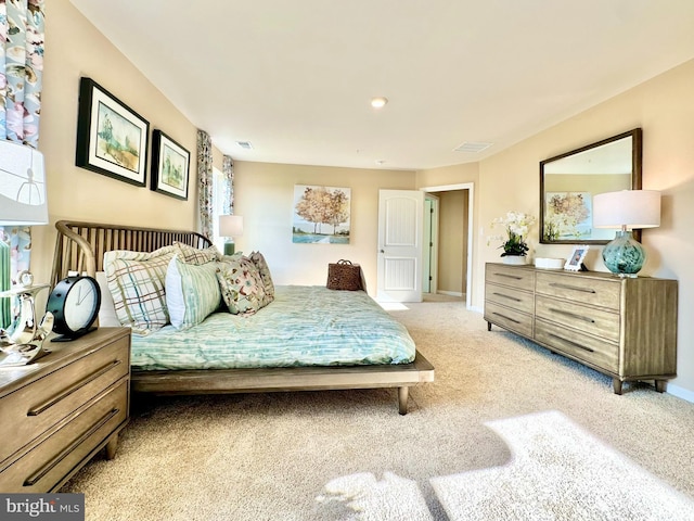 bedroom with light carpet, visible vents, and baseboards