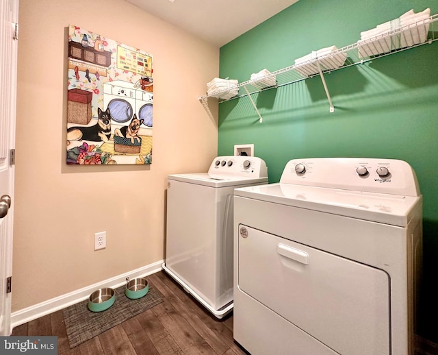 clothes washing area with laundry area, separate washer and dryer, dark wood-type flooring, and baseboards