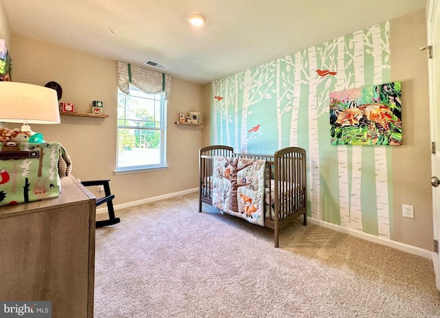 bedroom featuring a crib, carpet, visible vents, and baseboards