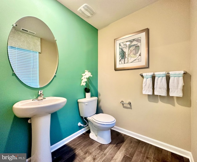 bathroom with visible vents, baseboards, toilet, and wood finished floors