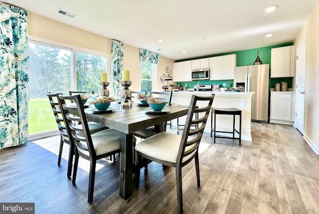 dining area with light wood finished floors, visible vents, recessed lighting, and baseboards