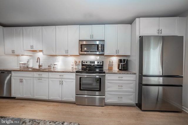 kitchen featuring a sink, light wood-type flooring, appliances with stainless steel finishes, and white cabinets