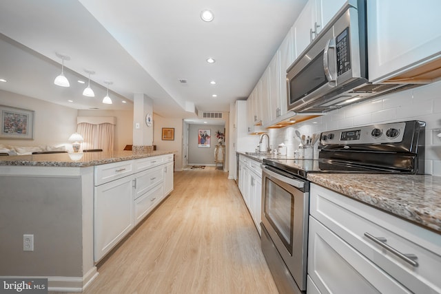 kitchen featuring visible vents, white cabinets, stainless steel appliances, and a sink