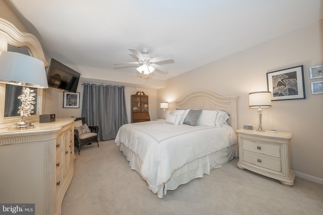 bedroom with a ceiling fan, baseboards, and light carpet