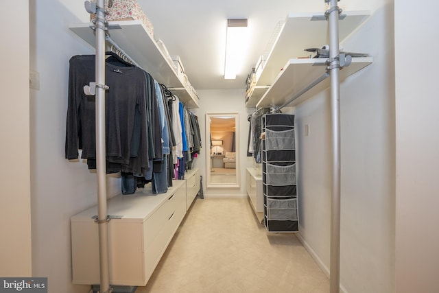 walk in closet with light floors