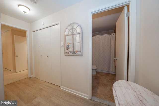 hall with wood finished floors and baseboards