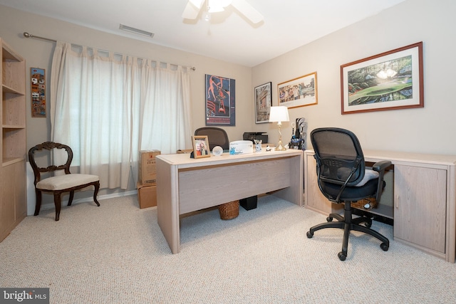 home office with light carpet, visible vents, and ceiling fan