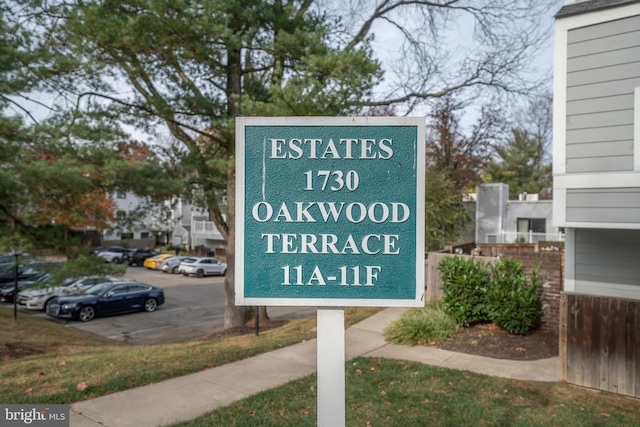 community / neighborhood sign featuring uncovered parking