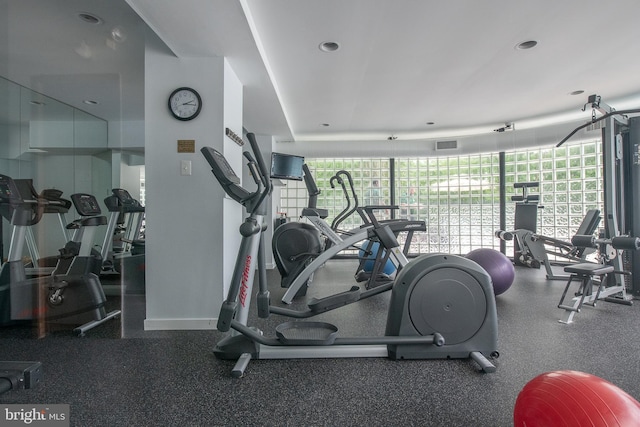 exercise room with a healthy amount of sunlight, visible vents, and baseboards