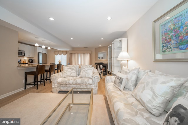 living area with recessed lighting, baseboards, and light wood-style floors