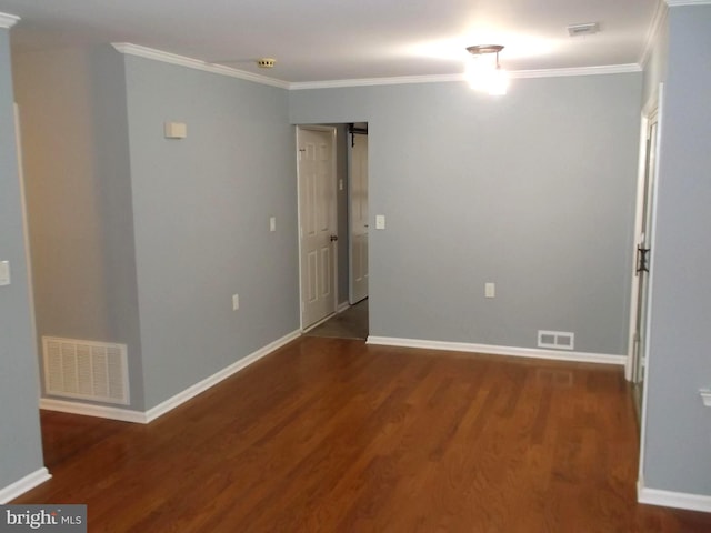 unfurnished room with visible vents, wood finished floors, baseboards, and ornamental molding