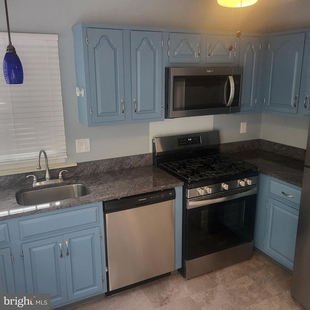 kitchen featuring a sink, stainless steel appliances, and blue cabinets