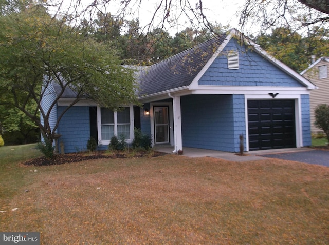 view of front of house featuring a front lawn, an attached garage, and roof with shingles