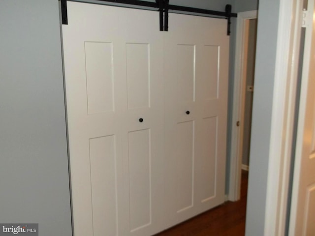 interior space with a barn door and dark wood-type flooring