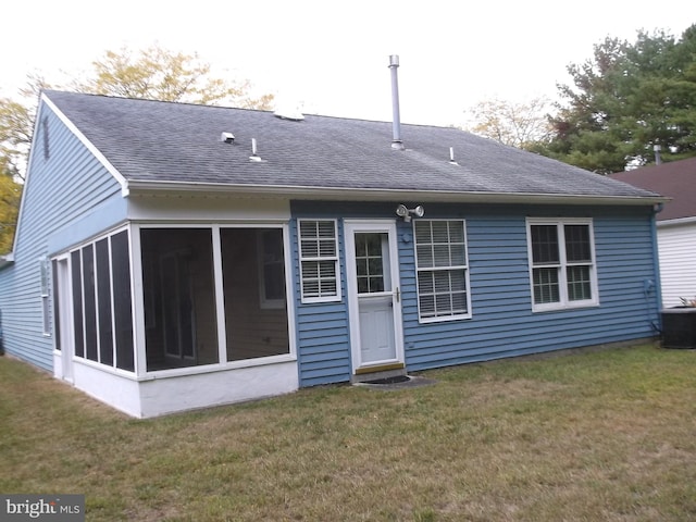 rear view of house featuring cooling unit, a shingled roof, a yard, and a sunroom