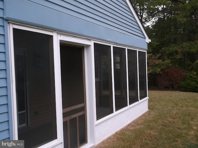 view of home's exterior with a lawn and a sunroom