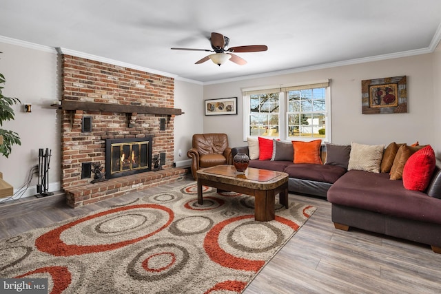 living area featuring a fireplace, wood finished floors, a ceiling fan, and ornamental molding