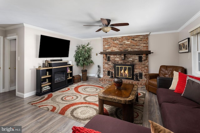 living room featuring a ceiling fan, wood finished floors, a fireplace, and ornamental molding