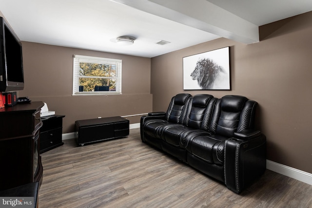 living area featuring wood finished floors, visible vents, and baseboards