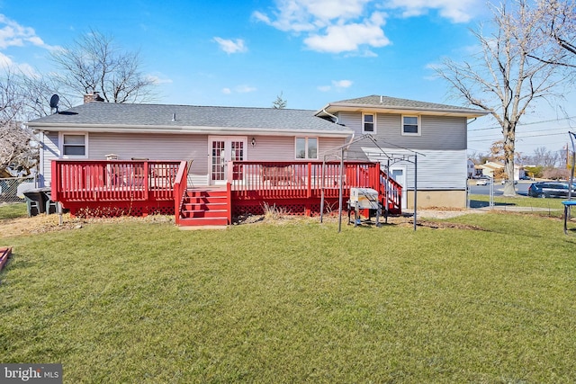 rear view of house featuring a yard, a wooden deck, and fence