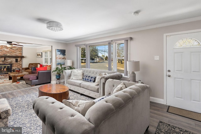 living room featuring a brick fireplace, baseboards, ceiling fan, ornamental molding, and dark wood-style floors