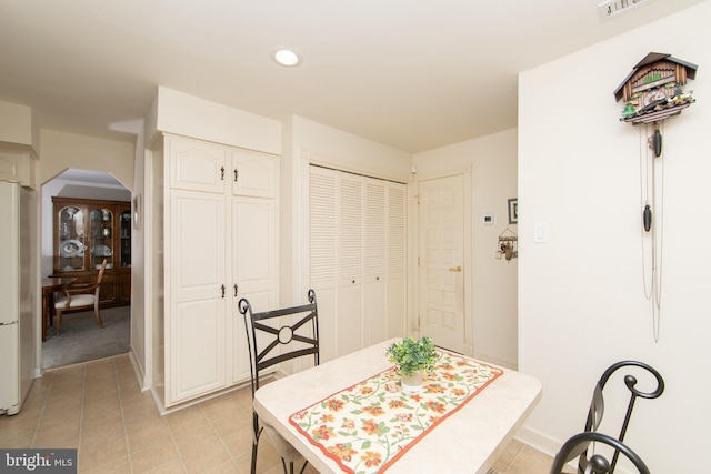 dining room featuring light tile patterned floors, recessed lighting, and arched walkways