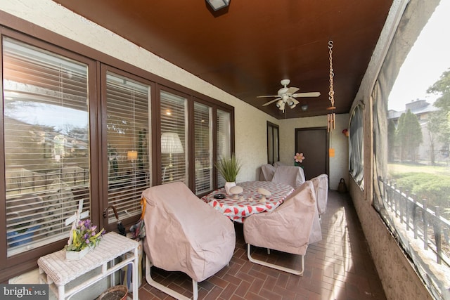 sunroom featuring a ceiling fan