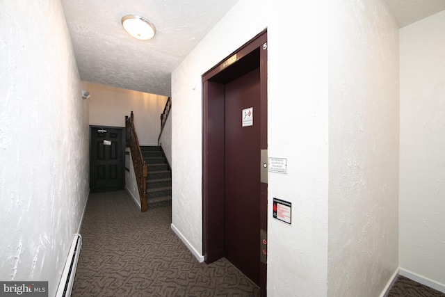 corridor with stairway, elevator, a textured ceiling, a baseboard heating unit, and carpet flooring