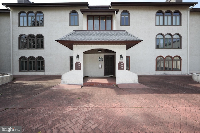 mediterranean / spanish home with a shingled roof and stucco siding