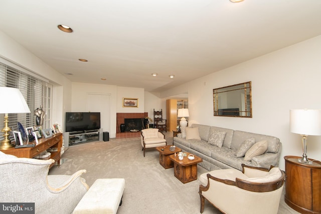 living area with a tiled fireplace, recessed lighting, and light colored carpet