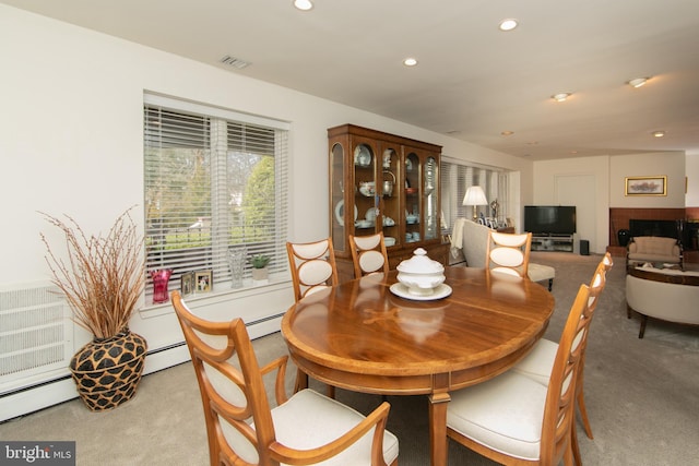 dining space featuring visible vents, a brick fireplace, a baseboard heating unit, carpet flooring, and recessed lighting