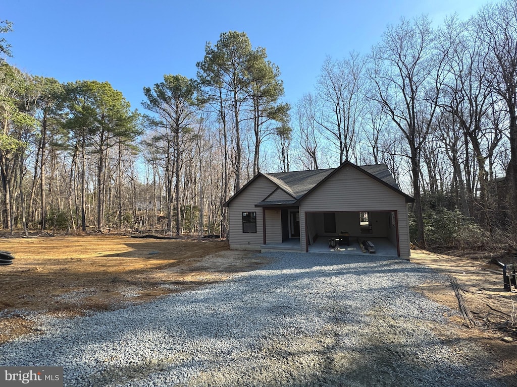 view of front of property with an attached carport and gravel driveway