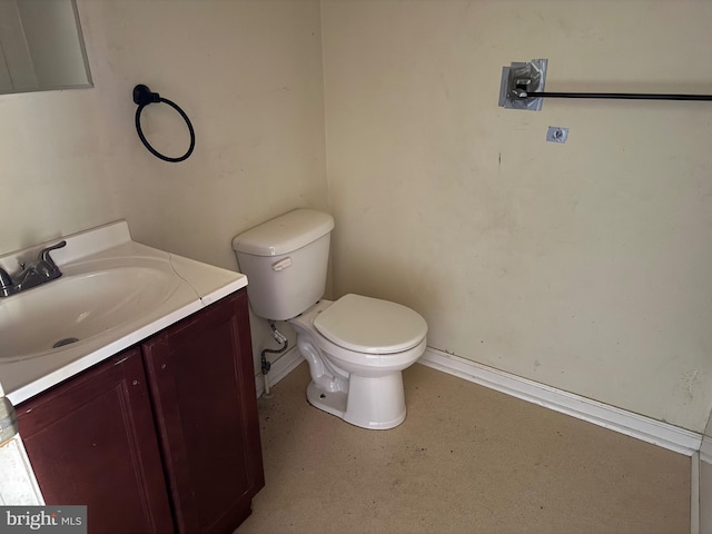 half bath featuring baseboards, toilet, and vanity