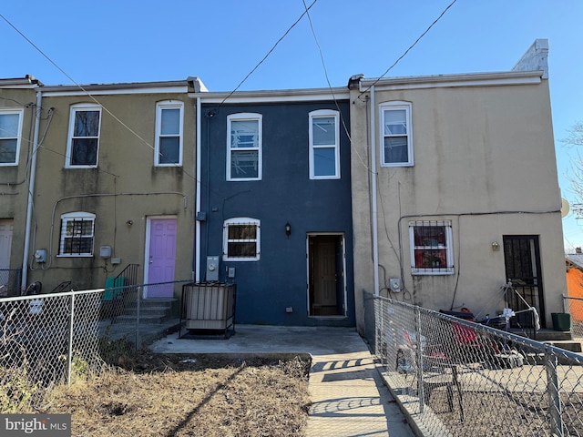 view of front of property featuring stucco siding and fence private yard