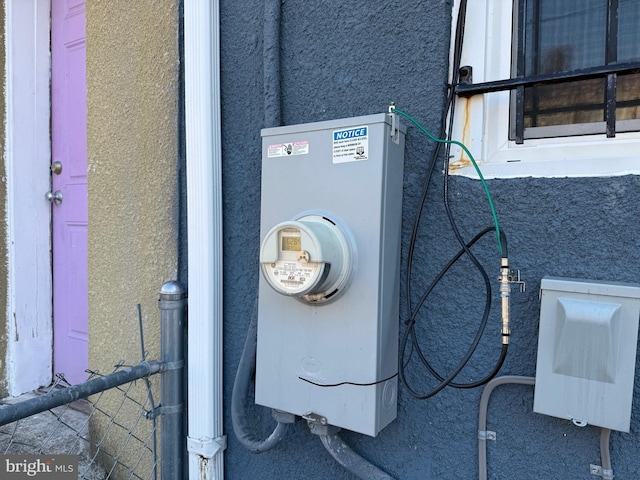 exterior details featuring stucco siding and electric meter