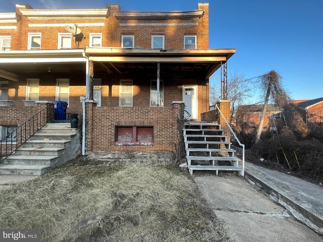 view of property with brick siding and stairs