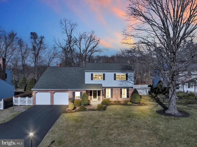 view of front of property featuring an attached garage, fence, brick siding, and driveway