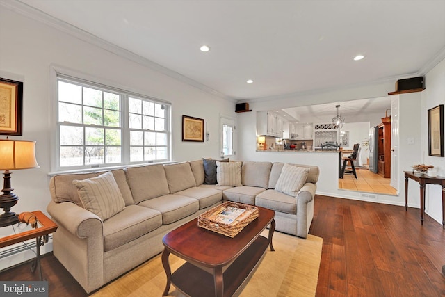 living area with recessed lighting, crown molding, baseboards, and wood finished floors