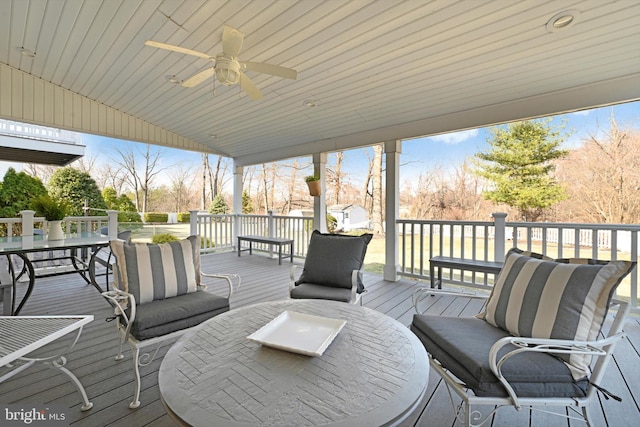 wooden deck with outdoor dining space and a ceiling fan