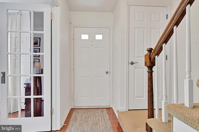 foyer featuring stairway, baseboards, and wood finished floors