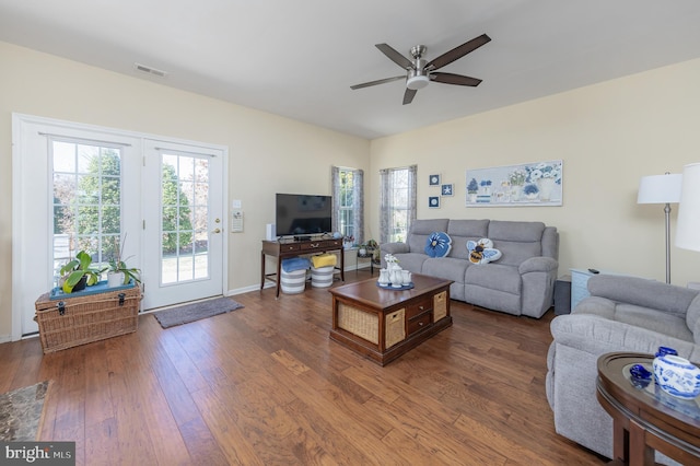 living area featuring visible vents, baseboards, a ceiling fan, and hardwood / wood-style flooring