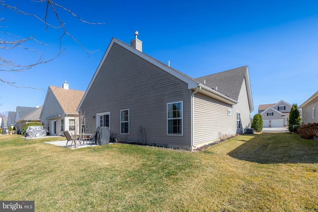 rear view of house with a patio area, central air condition unit, a lawn, and a chimney