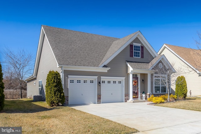 view of front of house with stone siding, a front lawn, driveway, and a shingled roof