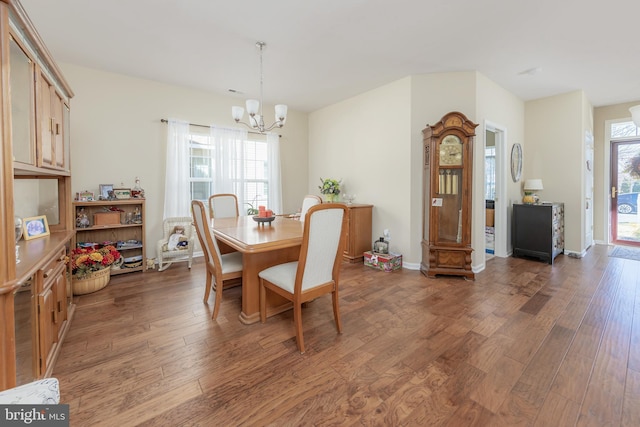 dining area with a chandelier, baseboards, and wood finished floors