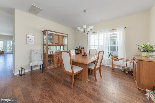 dining room with a notable chandelier, dark wood-style floors, visible vents, and baseboards