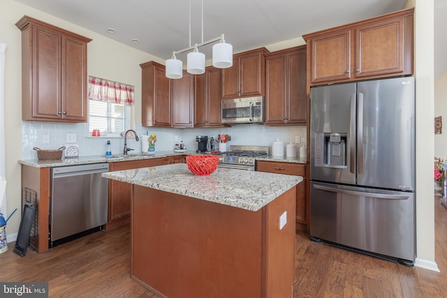 kitchen featuring dark wood finished floors, backsplash, stainless steel appliances, and a sink