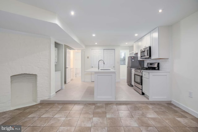 kitchen featuring white cabinetry, a center island with sink, appliances with stainless steel finishes, and a sink