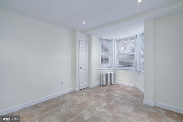 empty room with recessed lighting, baseboards, and radiator heating unit