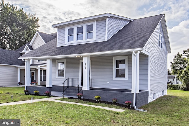 bungalow featuring a porch, a front lawn, and roof with shingles